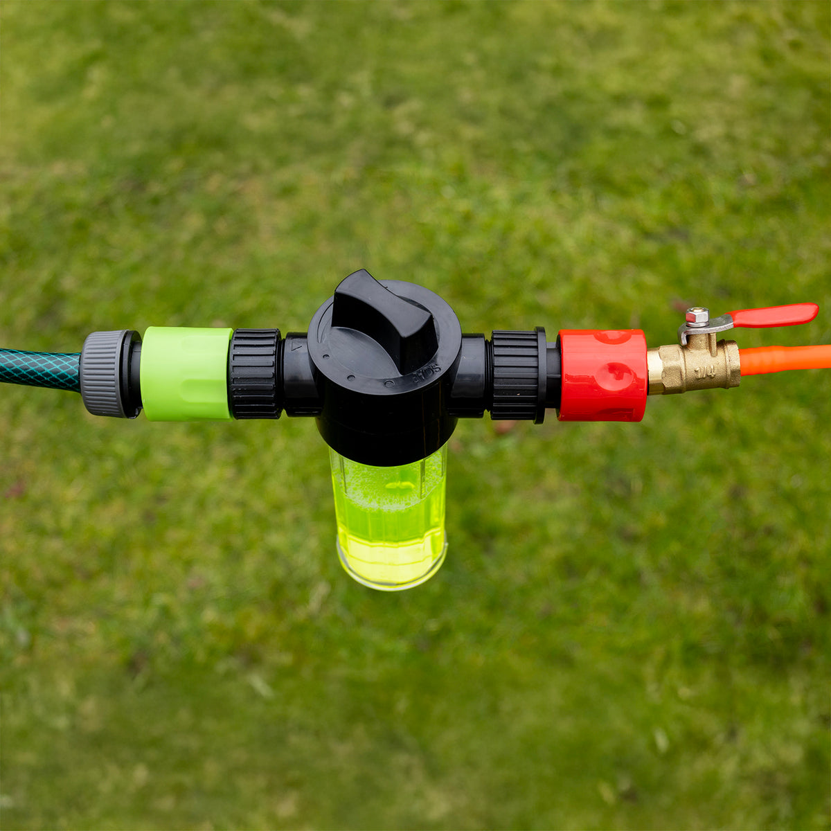 Zeepdispenser gekoppeld tussen de tuinslang en de slang van de wasborstel